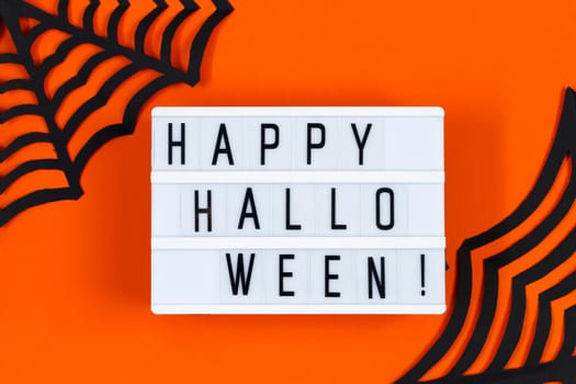 Happy Halloween. Paper decor for the holiday on an orange background. Place for text.