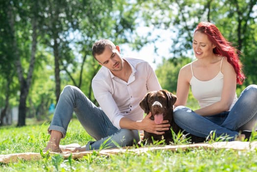 A couple and their dog in the park. Spending time with friends