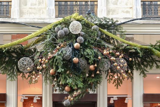 Decoration made from fir branches and golden balls on the wall of a shop