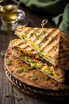 Healthy toasts with avocado, cheddar cheese and tomatoes for breakfast or lunch. Vegetarian sandwiches. Plant-based diet. Whole food concept.