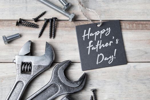 Happy father's day. Greeting card. Old work tools on a gray wooden background.