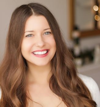 Christmas time and holiday mood concept. Happy smiling woman and decorated xmas tree lights on background.