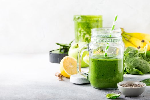 Healthy breakfast with green smoothie in glass jar and ingredients. Detox, diet, healthy, vegetarian food concept with copy space.