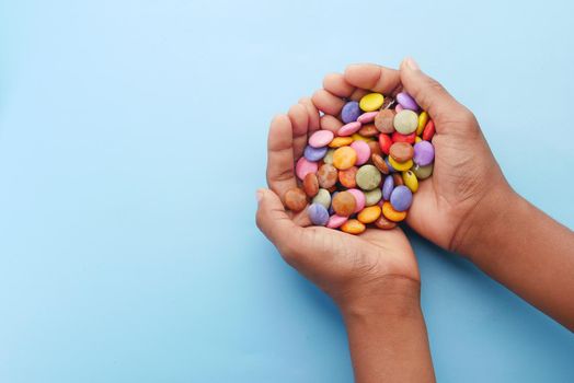 child boy picking multi-colored sweet candies top view.