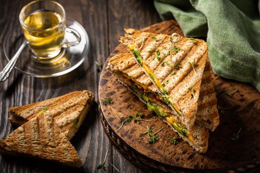 Healthy toasts with avocado, cheddar cheese and tomatoes for breakfast or lunch. Vegetarian sandwiches. Plant-based diet. Whole food concept.