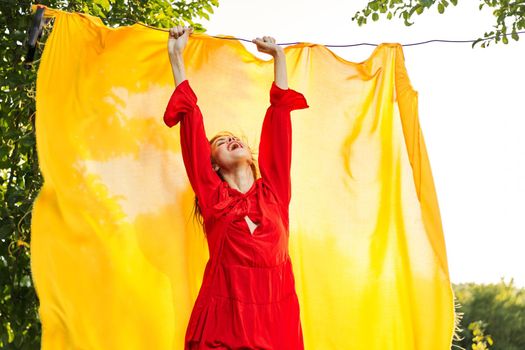 beautiful woman posing in red dress outdoors yellow cloth. High quality photo