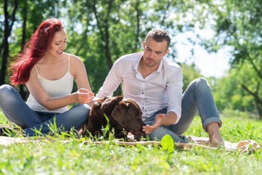 A couple and their dog in the park. Spending time with friends