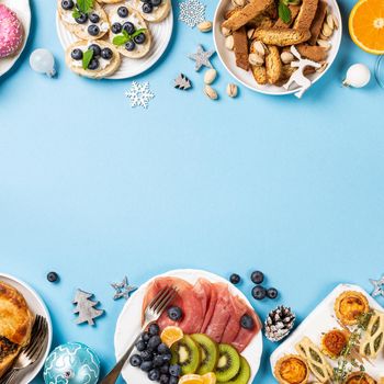 Chtistmas holiday food concept background with dinner party table over blue, top view, flat lay with copy space