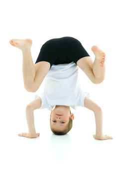 Cute little boy doing a headstand. The concept of children's sports. Isolated on white background