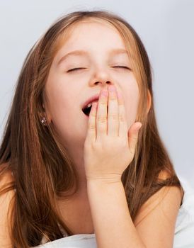 Portrait of beautiful little girl yawning