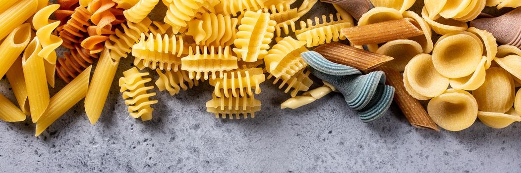 Food background with assorted colorful italian pasta. Concept for menu, cafe, restaurant. Copy space, flat lay, top view, banner.