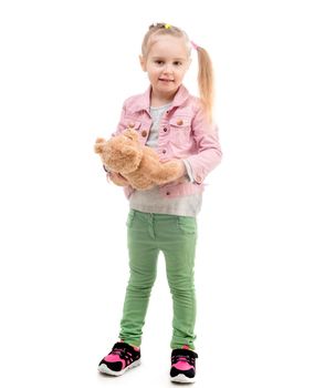 Cute girl standing with her teddy toy, cute little ponytails, isolated on white background