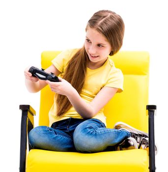 Pretty teen girl sitting, holding black joystick, playing console for computer games