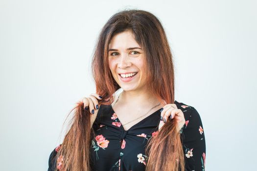 Close up portrait of funny attractive pretty girl with long ginger fair hair standing on white background