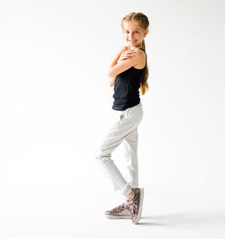 Happy little girl smiling standing in front of camera on white background