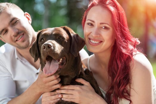 A couple and their dog in the park. Spending time with friends