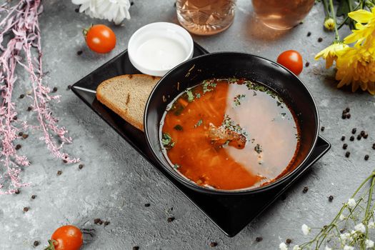 Traditional Ukrainian Russian borscht with white beans on the black bowl. Flat lay. Top view.