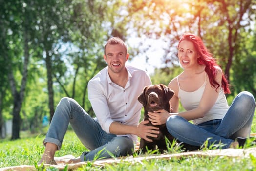 A couple and their dog in the park. Spending time with friends