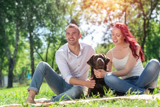 A couple and their dog in the park. Spending time with friends