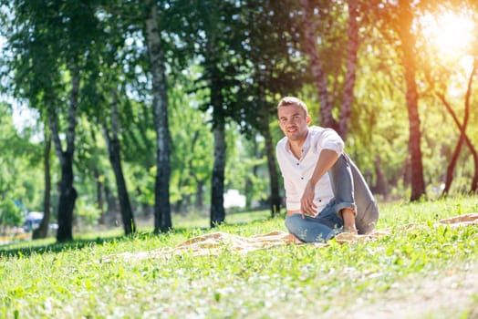 Portrait of a young man in the park. Smiling and happy