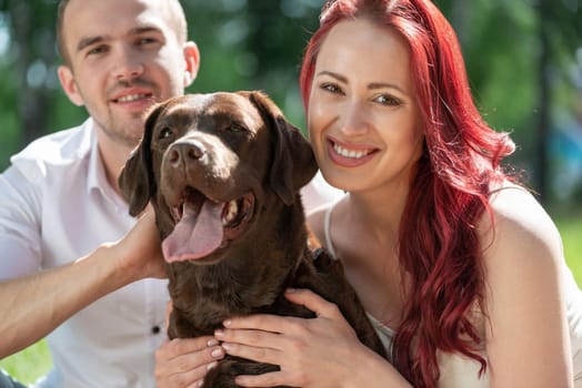 A couple and their dog in the park. Spending time with friends