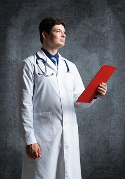 Doctor with tablet for documents, scans documents against the background of the wall