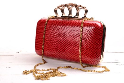 Red wallet purse with brass knuckles on white background.