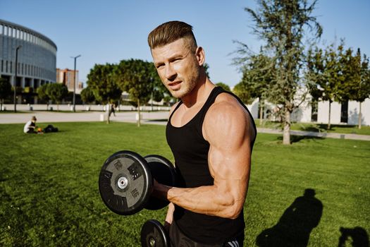 sporty man in black t-shirt in the park training lifestyle. High quality photo