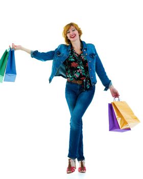 A beautiful young woman happily shopping with large multi-colored paper bags. The concept of sales, upcoming holidays. Isolated on white background.