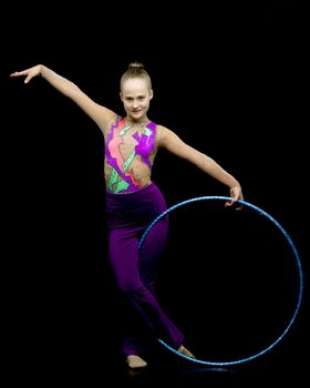 A girl gymnast performs an exercise with a hoop. The concept of gymnastics and fitness. Isolated.