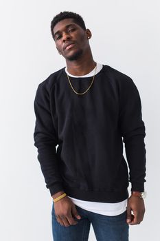 Studio shot of young handsome African man wearing hoodie against white background.