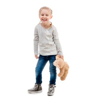 Little girl with her favorite teddy bear toy, posing isolated on white background