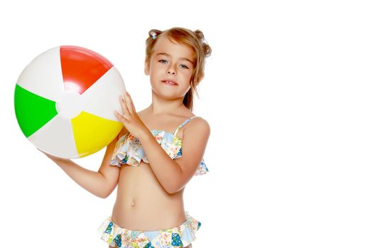 A little girl in a swimsuit is playing with a big ball. The concept of a family vacation at sea, happy childhood.Isolated on white background.