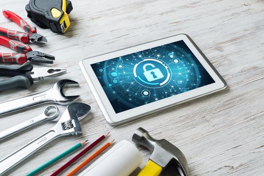 Tablet pc with security concept on screen and industrial tools around