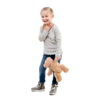 Little girl with her favorite teddy bear toy, posing isolated on white background