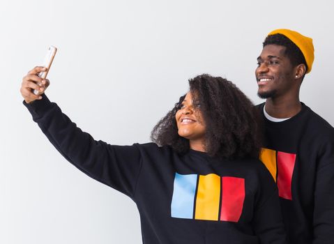 Friendship and fun concept - Group of friends afro american men and woman taking selfie in studio on white background