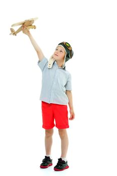 Happy kid boy plays with wooden toy airplane.Isolated on white background.