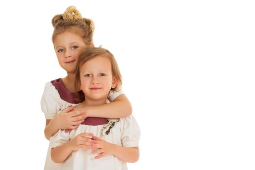 Girls in matching dresses hug - Isolated on white background