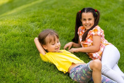 Portrait of two little girls sisters fighting on home backyard. Friends girls having fun. Lifestyle candid family moment of siblings quarreling playing together.