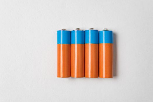 Four AA alkaline batteries on white background. Main battery for personal power supplies