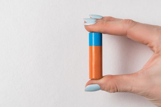 Female hand holding AA battery on white background. Accumulator Copy space.