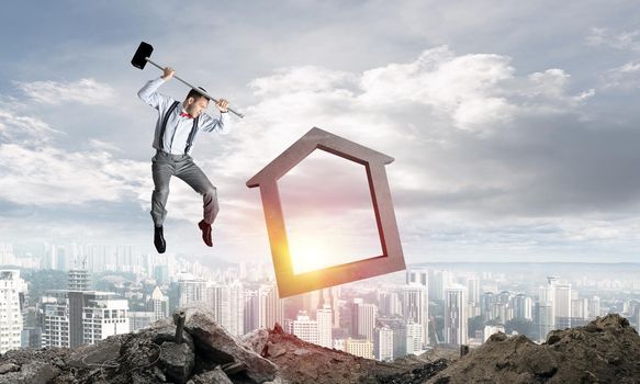 Jumping businessman crashing big house symbol with city view and sunlight on background. 3D rendering.