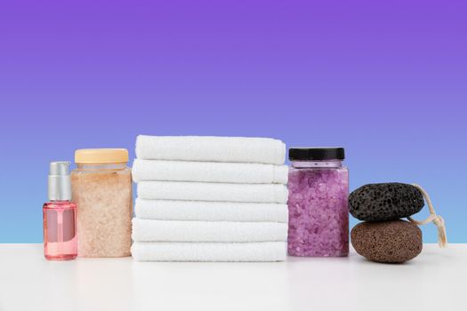 Bath towels and spa salt on white table, close up