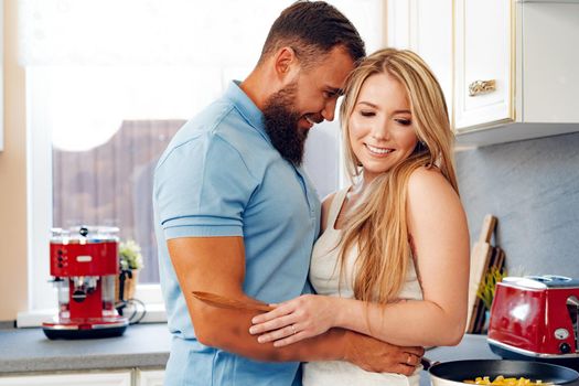 Young loving couple cooking together in kitchen at home