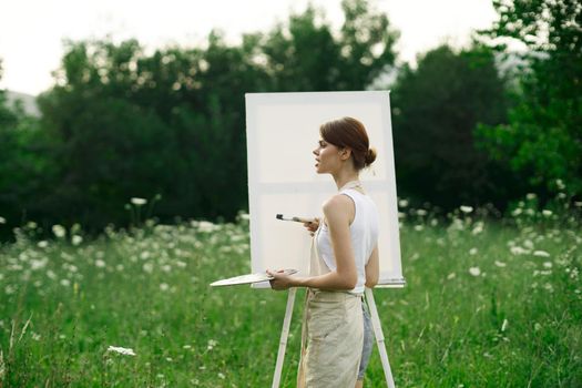 woman artist outdoors easel drawing creative landscape. High quality photo