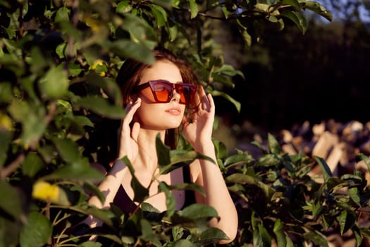 pretty woman wearing sunglasses green leaves glamor posing summer. High quality photo