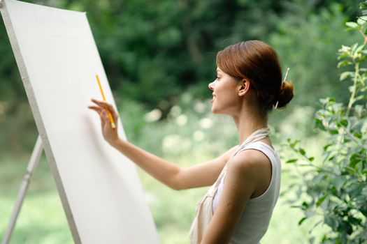 woman outdoors painting a picture easel art hobby. High quality photo