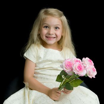 Beautiful little girl with a bouquet of flowers on a black background. The concept of a happy childhood, beauty and fashion.