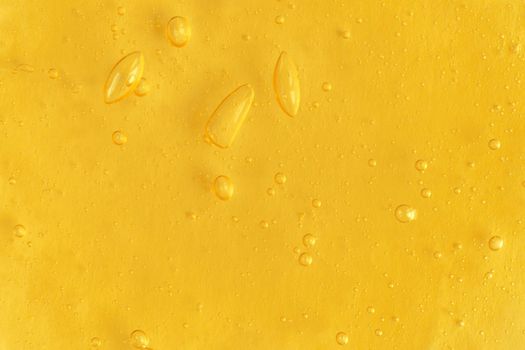 Texture of transparent yellow antiseptic gel with air bubbles on light monochrome background. Concept of skin moisturizing and prevention of virus. Liquid beauty product closeup. Backdrop, flat lay