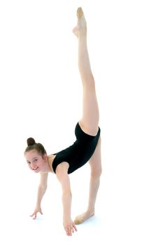 A girl gymnast performs an acrobatic element. The concept of childhood, sport, healthy lifestyle. Isolated on white background.